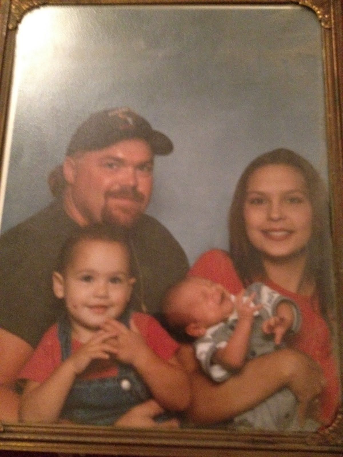 Framed family portrait of Neil with three young children