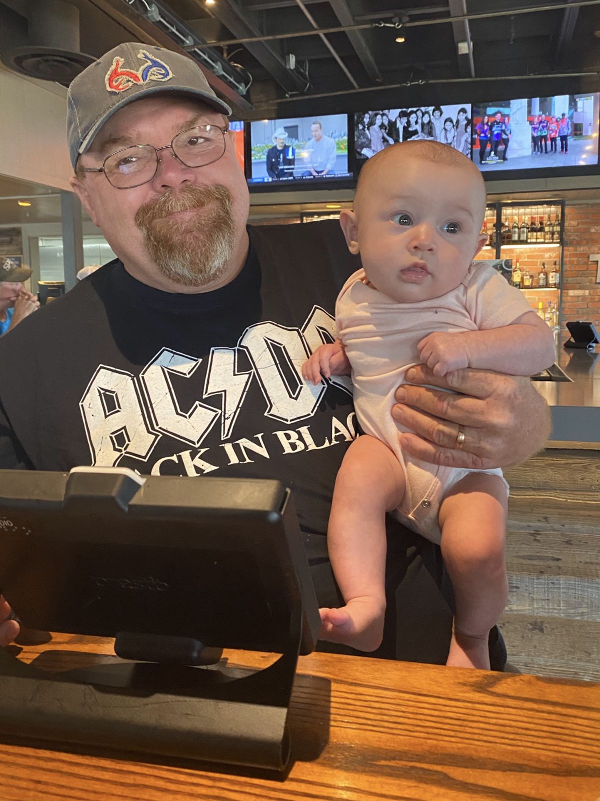 Neil in an AC/DC shirt holding a baby