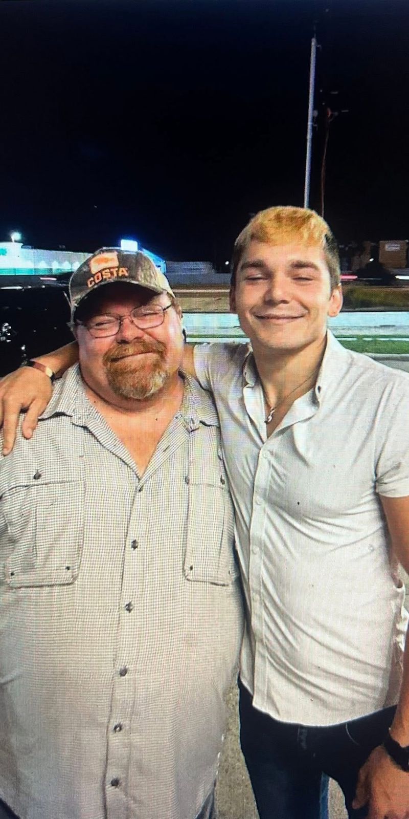 Neil with a younger man outdoors at night