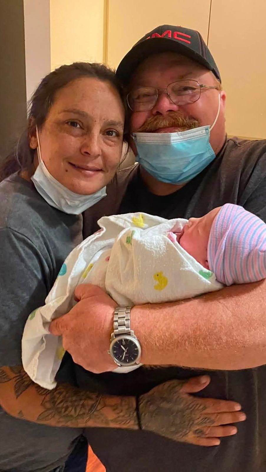 Neil holding a newborn beside a family member