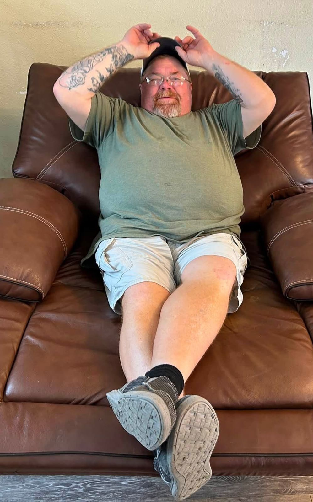 Neil reclining in a leather armchair, smiling