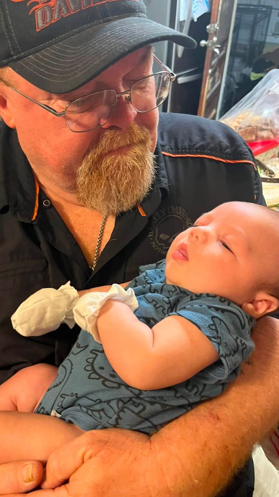 Neil looking down at a sleeping baby in his arms