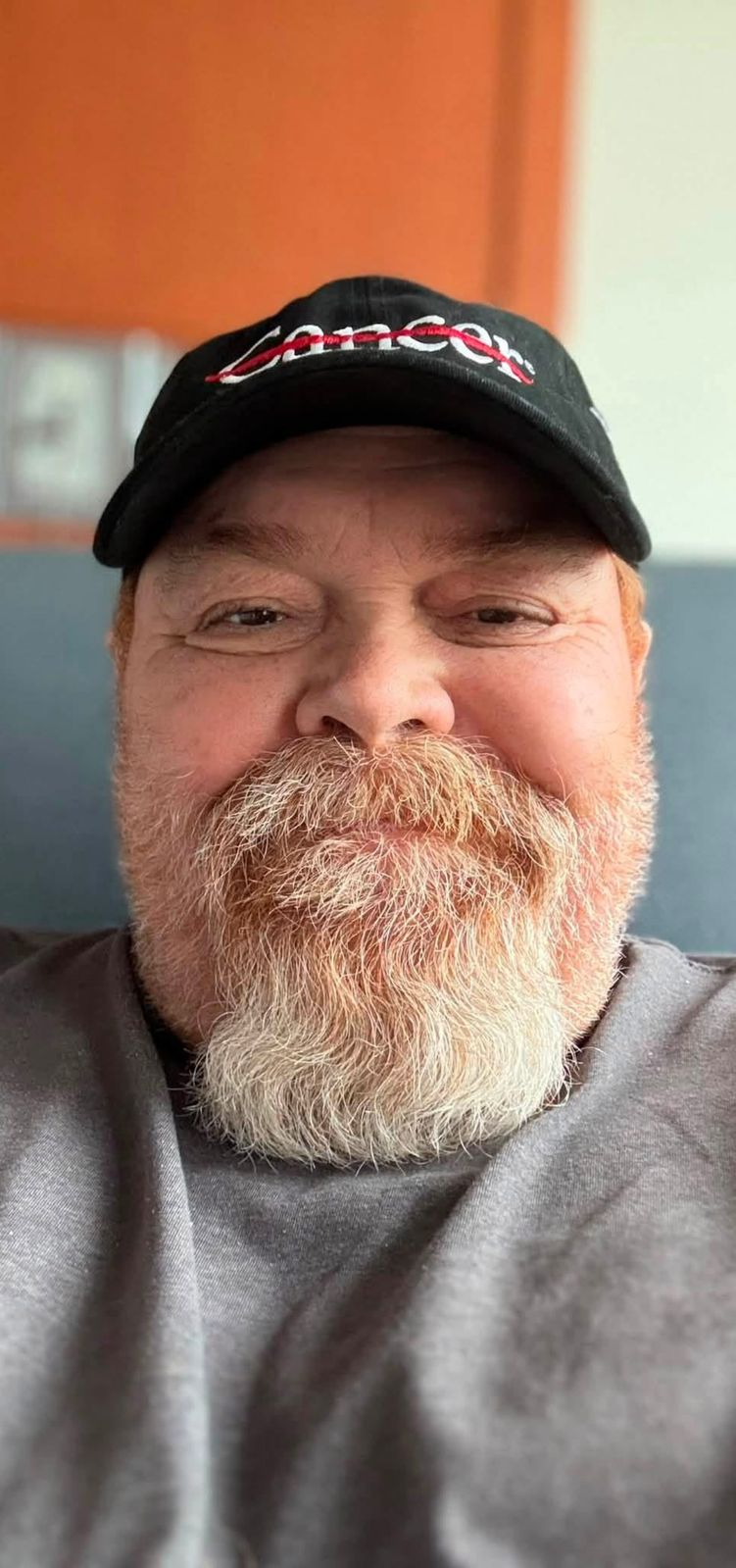 Neil wearing a black Cancer baseball cap