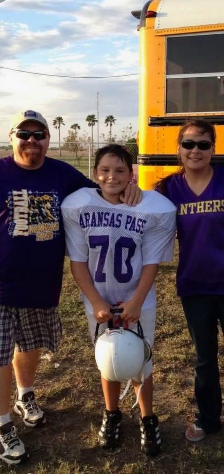 Neil with family in front of a yellow school bus