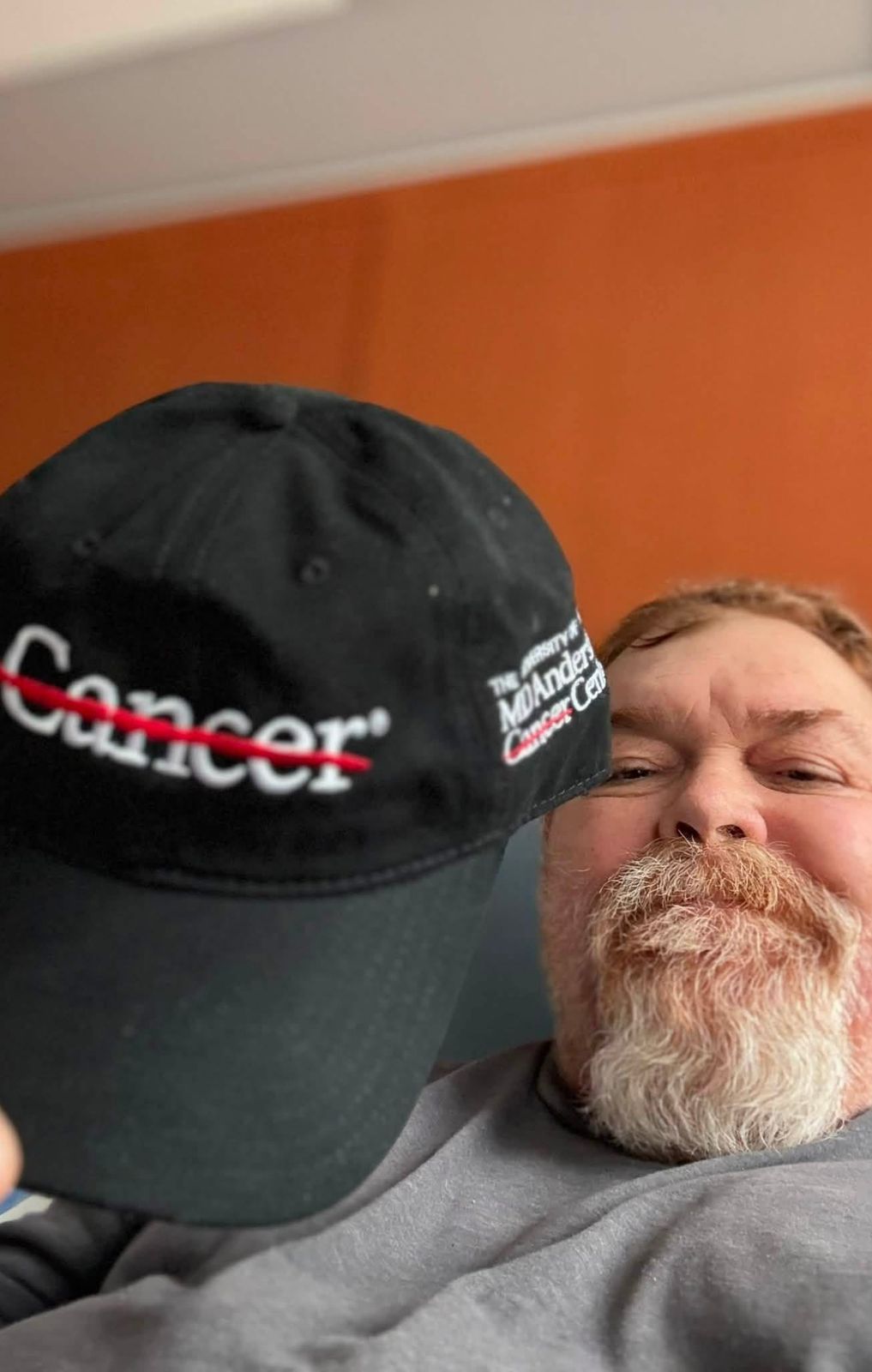 Neil in a Cancer hat leaning in for a selfie