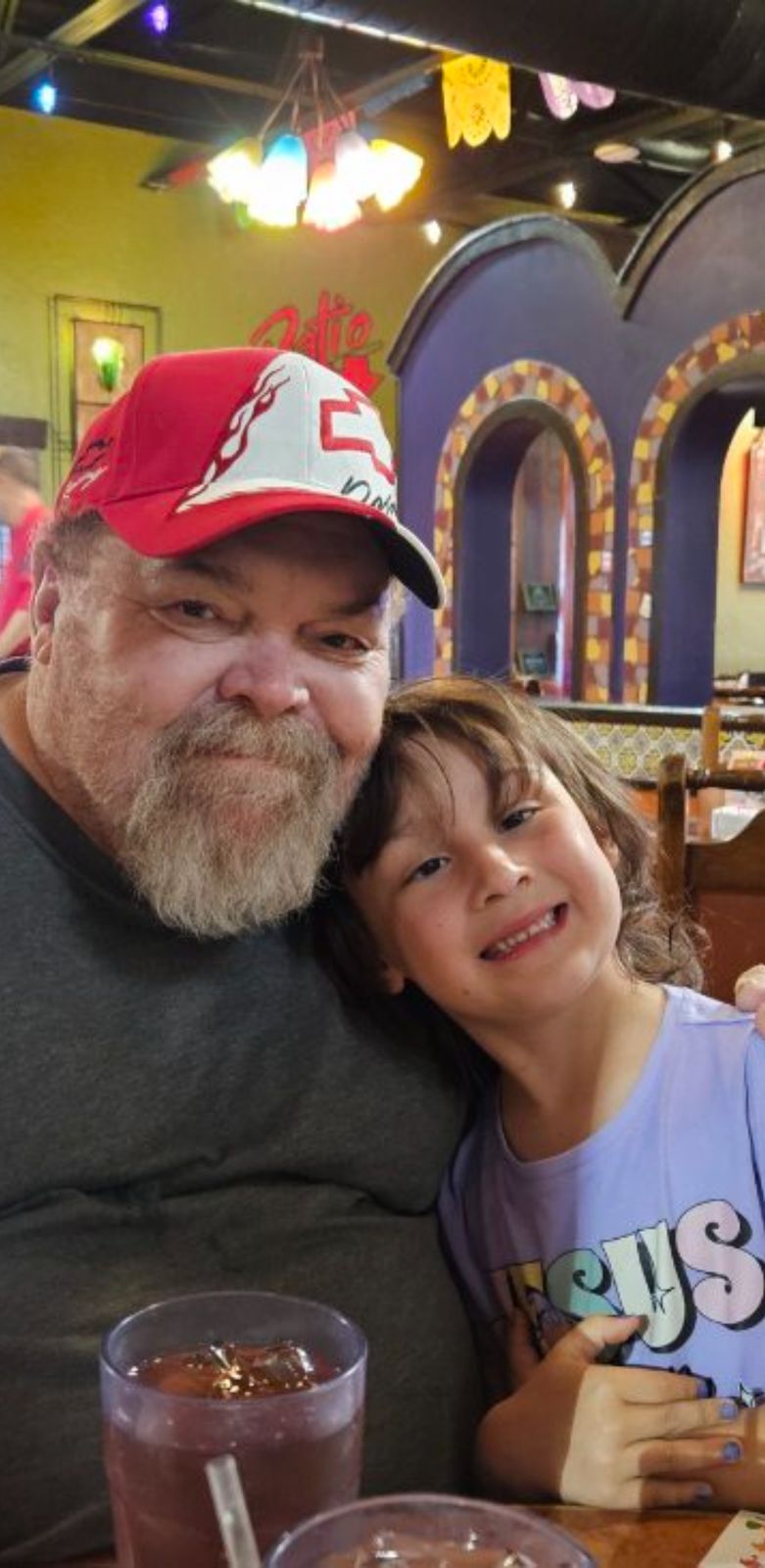 Neil smiling next to a young girl in a purple shirt