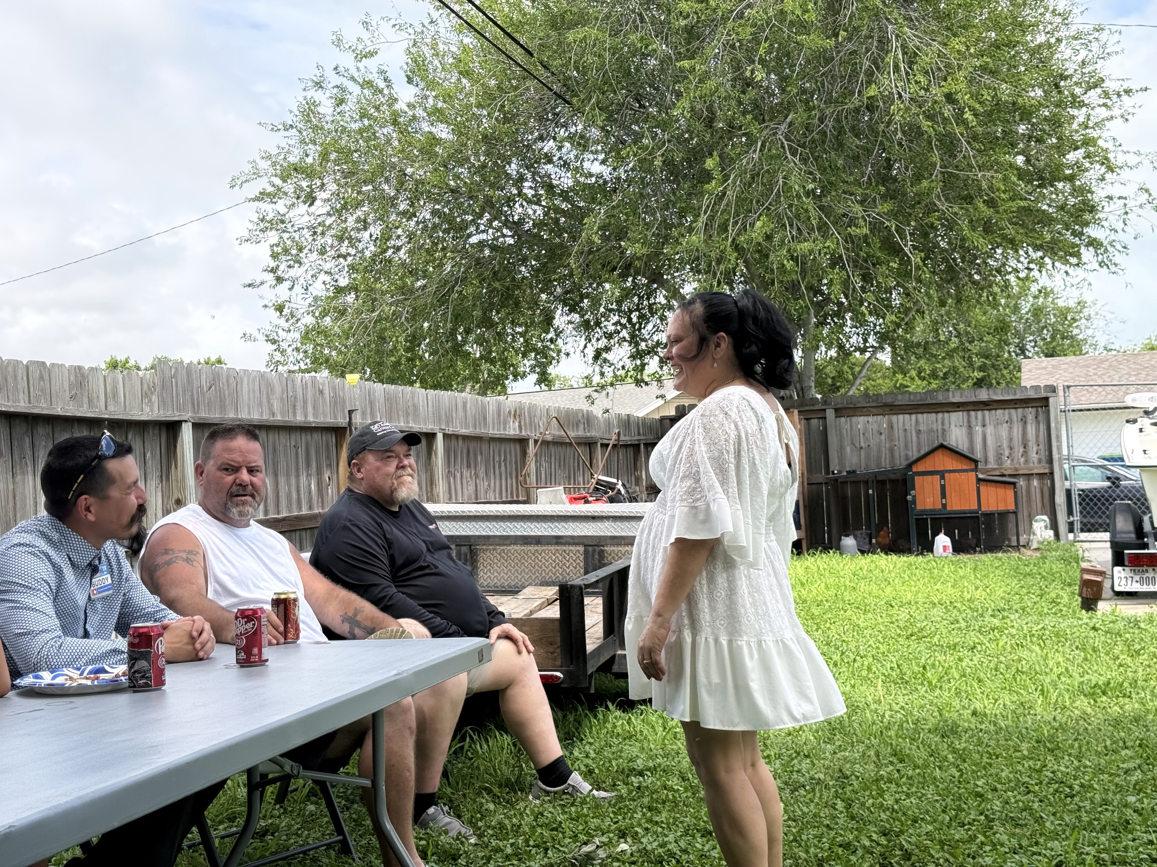 Friends gathered at a backyard table with drinks