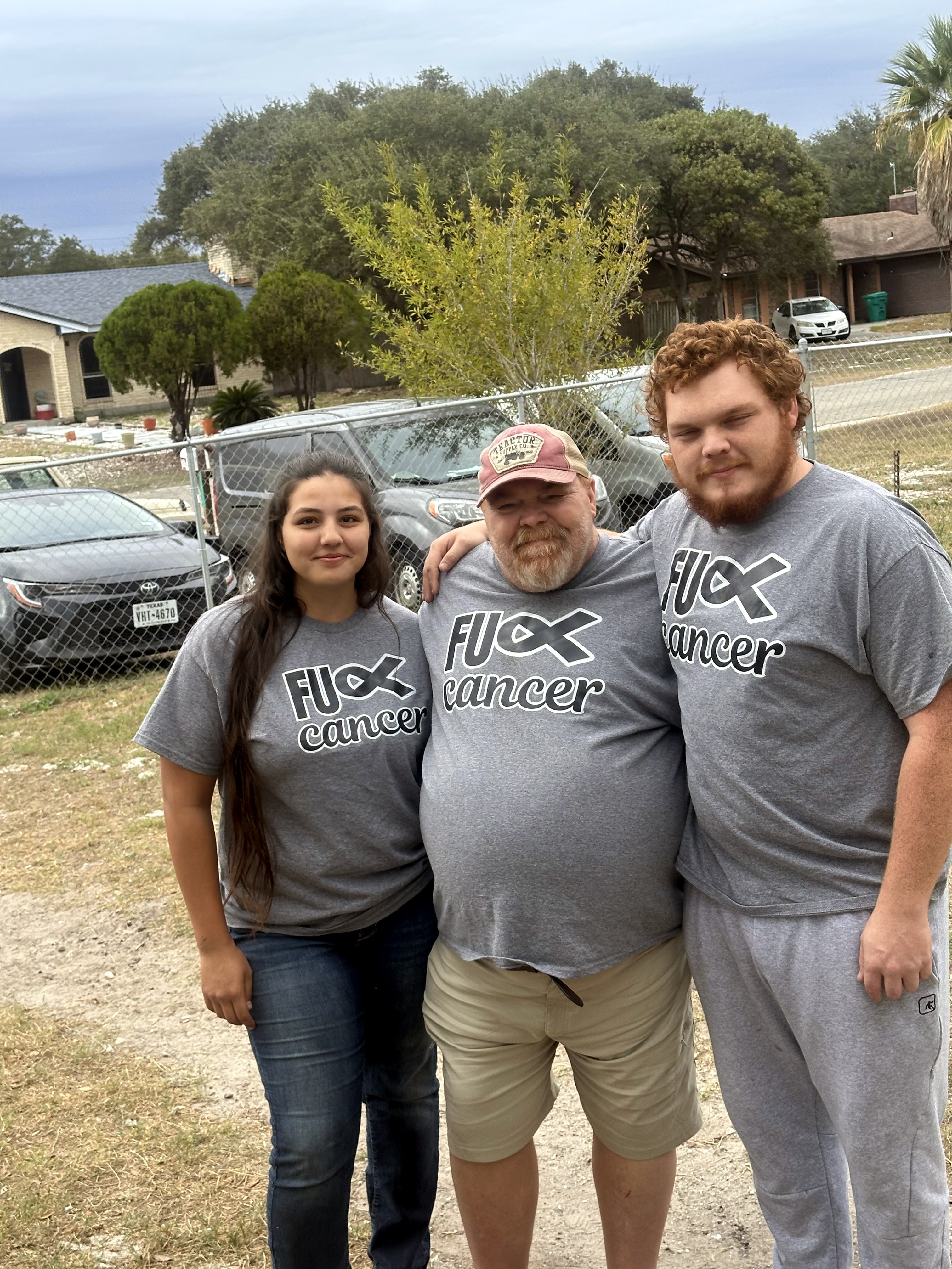 Neil with two younger people in matching cancer awareness shirts