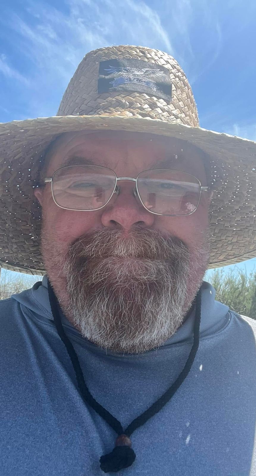 Neil smiling in a straw hat